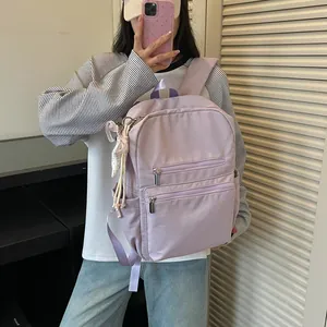 Vista detallada de una mochila ligera lila de estilo coreano para mujer con cinta decorativa