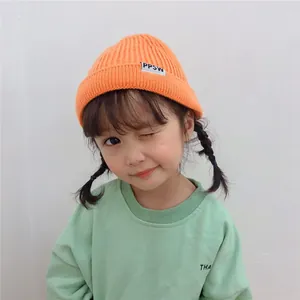 Adorable Asian child model wearing orange ins style knitted beanie hat with PPSW label detail