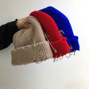 Detail of hip-hop knit beanies with metal rings and decorative safety pins