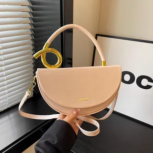 Detailansicht einer minimalistischen Halbmond-Satteltasche mit goldenem Metall-Akzent