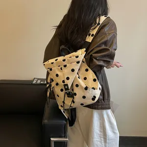 Detailed visual of a stylish polka dot canvas backpack being worn for a commuter lifestyle look