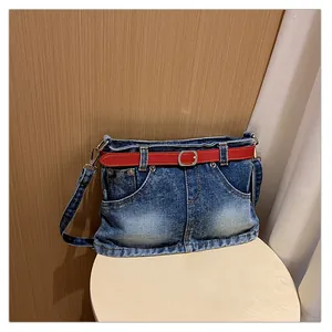 Creative denim shoulder bag with a skirt-like design and a vibrant red belt detail.
