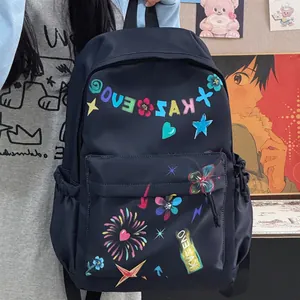 Detailed view of a black fashion backpack with colorful graffiti heart and star prints.