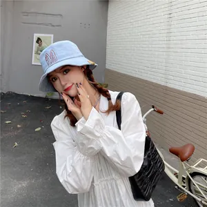 Charming light blue bucket hat with cute embroidered bunny ears on an Asian model.