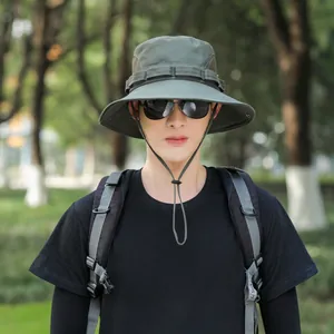 Close-up of a man wearing a dark green outdoor sun bucket hat with adjustable chin strap.