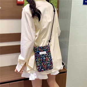 Borsina porta cellulare con paillettes colorate indossata sopra una camicia gialla