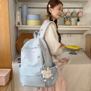 Sweet light blue backpack for girls featuring cute cartoon prints and plush keychain