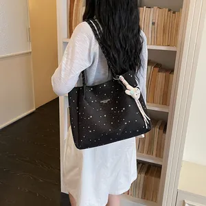 Sac cabas noir à motif étoiles avec breloque lapin mignon dans une bibliothèque