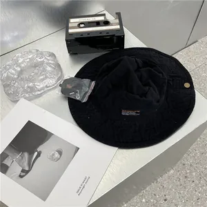 Detailopname van een zwarte vissershoed met vintage label en afneembare kinriem