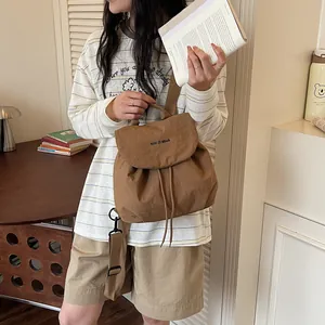 Gros plan d'un sac à dos marron léger à cordon porté par un mannequin dans un cadre intérieur