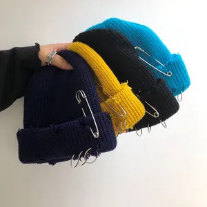 Detailed view of streetwear hip-hop knit beanies featuring decorative metal rings and pins