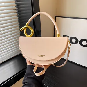 Detailaufnahme einer beigen Satteltasche mit einem goldenen Knoten-Griff