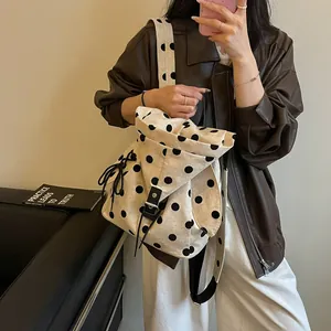 Close-up of casual polka dot backpack with drawstring and leather buckle detail