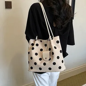 Close-up of a vintage polka dot canvas tote bag with a small hanging coin purse.