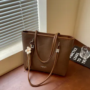 Large brown textured tote bag with elegant flower charm detail for women's daily commute