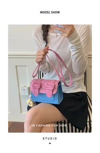 Model showcasing a stylish pink and blue color-block crossbody bag with an adjustable strap