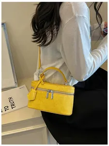 Compact yellow suede box handbag shown as a crossbody vanity bag for summer fashion