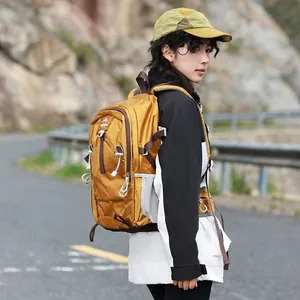 Woman wearing a yellow waterproof hiking backpack outdoors on a mountain road