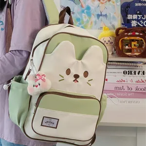 Detailed view of the cute cat-themed green school backpack with a plush bunny charm