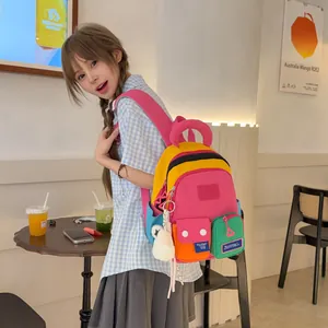 Trendy multi-color patchwork backpack worn by a female model in a stylish cafe setting
