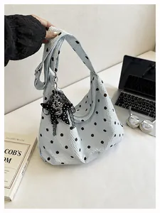 Detailopname van een blauwe hobo tas met polkadots, unieke bubbeltextuur en sterbedel