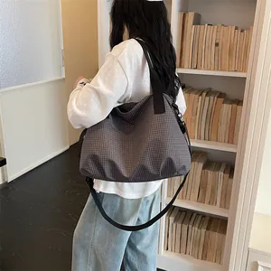 Grande borsa tote da viaggio a quadretti per sport e fitness indossata da una modella