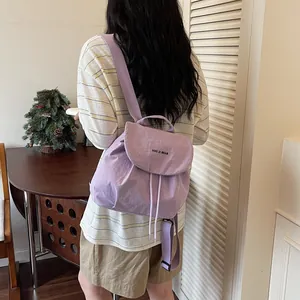Vue détaillée d'un sac à dos de voyage violet clair porté par une personne au quotidien.