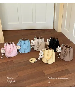 A diverse set of fashionable vegan leather bucket bags in pastel colors with cute bear charms