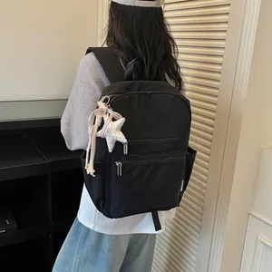 Vista posterior de una mujer con una mochila negra ligera de estilo coreano