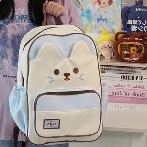 Close-up of cute cat-themed cream and blue backpack featuring large capacity storage