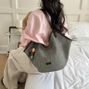 Detailed lifestyle view of large woven straw tote bag with colorful bead charms for summer