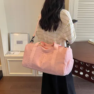 Vista lateral detallada de la bolsa de viaje rosa estampada de gran capacidad con correa