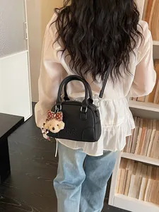 Black Boston commuter handbag for women with cute teddy charm and crossbody strap
