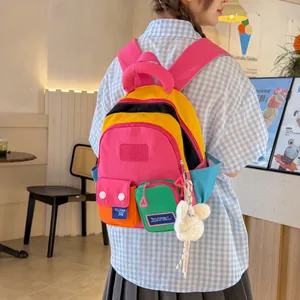 Trendy multi-color patchwork student backpack with cute plush keychain accessory