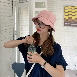 Asian model wearing a stylish pink ruffled bucket hat in a bright natural lifestyle setting