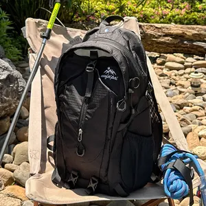 Detailansicht des großen schwarzen Outdoor-Wanderrucksacks in einer natürlichen Camping-Umgebung.