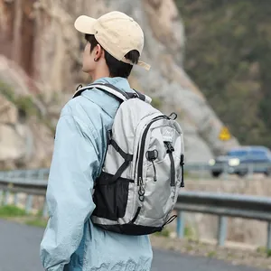 Lightweight grey waterproof outdoor hiking backpack for travel and school on a male model