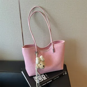 Detailed shot of a stylish pink large capacity tote bag with a cute teddy bear charm