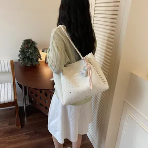 Grand sac cabas blanc élégant avec motifs d'étoiles porté à l'épaule dans une pièce