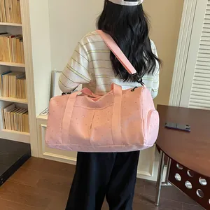 Vista trasera de modelo con una bolsa de viaje rosa grande con patrón de luna y estrellas