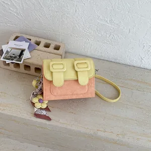 Detailed view of two-tone crossbody bag with decorative buckles and floral scarf