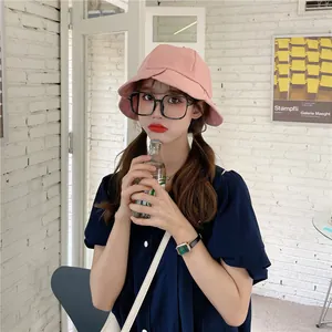 Close-up of a stylish pink ruffled bucket hat with wide brim worn by a female model.