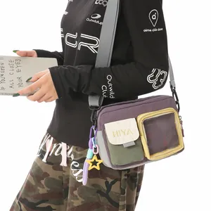 Close-up of a purple crossbody sport bag with multiple pockets and a clear window