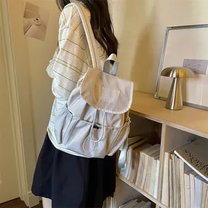 Detail view of a stylish beige ruched drawstring backpack for summer travel.