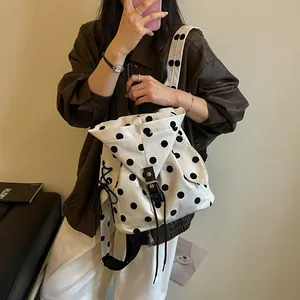 Detailed shot of a stylish casual polka dot backpack featuring rabbit ear flaps and metal buckle.