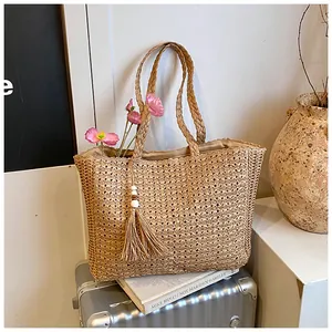 Vue détaillée du sac cabas en paille tissé à la main avec pompon et fleurs