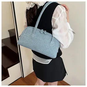 Fashionable denim texture underarm tote bag for women shown as a shoulder carry detail