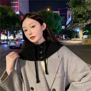 Detailed view of a black winter knitted hood scarf featuring stylish buttons on a model