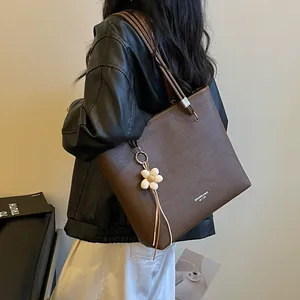 Large capacity brown textured leather tote bag for women with decorative flower charm