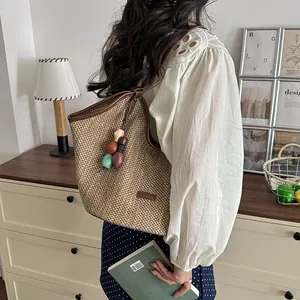 Detailed view of handmade straw woven tote bag with colorful bead charms for beach vacation
